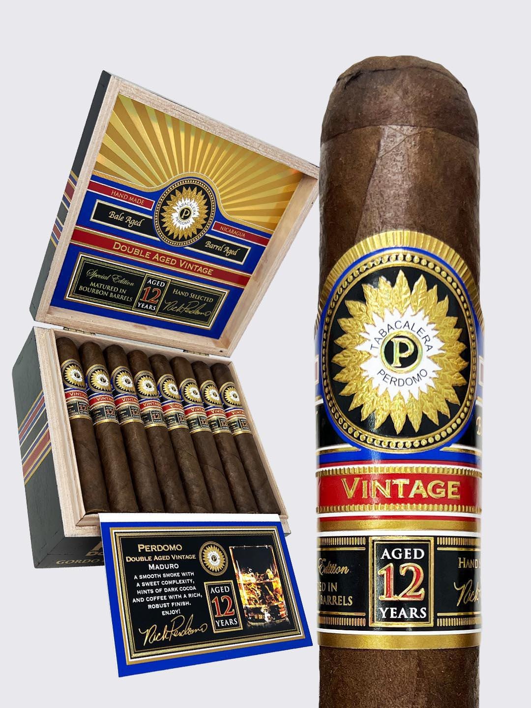 Perdomo-Double-Aged-12-Year-Vintage-Maduro-Robusto Perdomo Double Aged 12 Year Vintage Maduro Robusto cigar displayed next to its wooden box featuring ornate blue, red, and gold banding with 'AGED 12 YEARS' prominently displayed