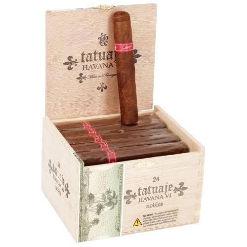 Tatuaje Havana VI Nobles cigar with its distinctive red band resting against open wooden box displaying multiple cigars with Tatuaje Havana VI branding