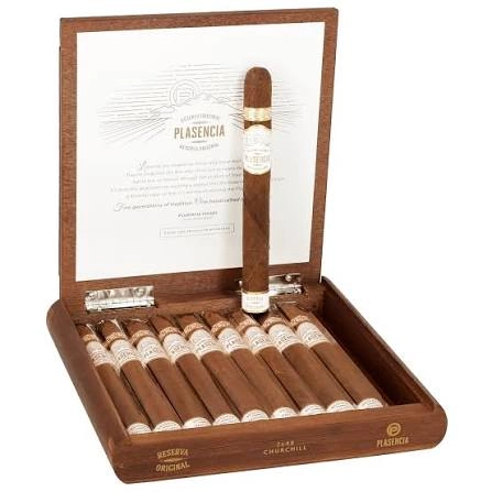 Open wooden box of Plasencia Reserva Original Churchill cigars, one cigar displayed upright in a silver stand, ten more lined up below.